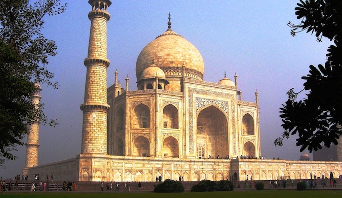 The iconic Taj Mahal on a sunny day in India surrounded by tourists