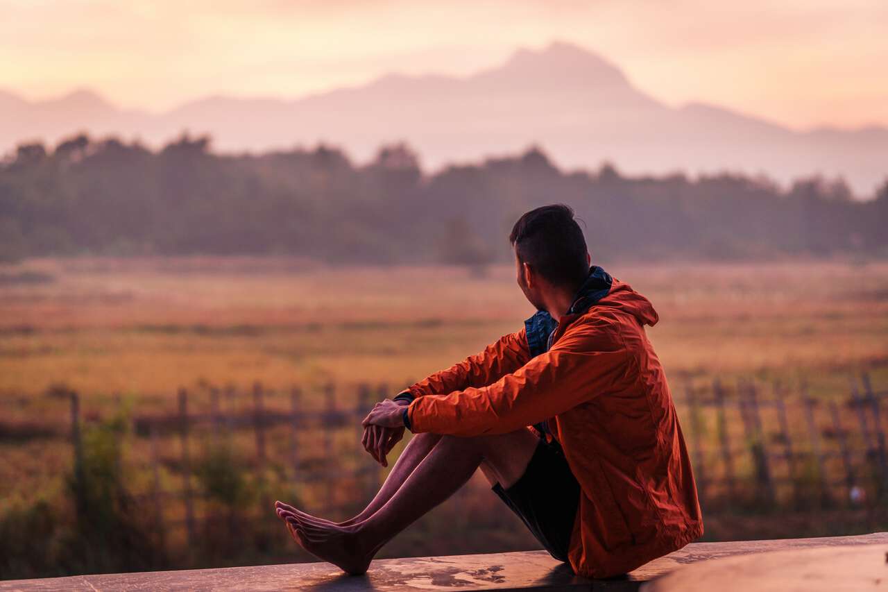 A backpacker watching the sunrise in Phrae